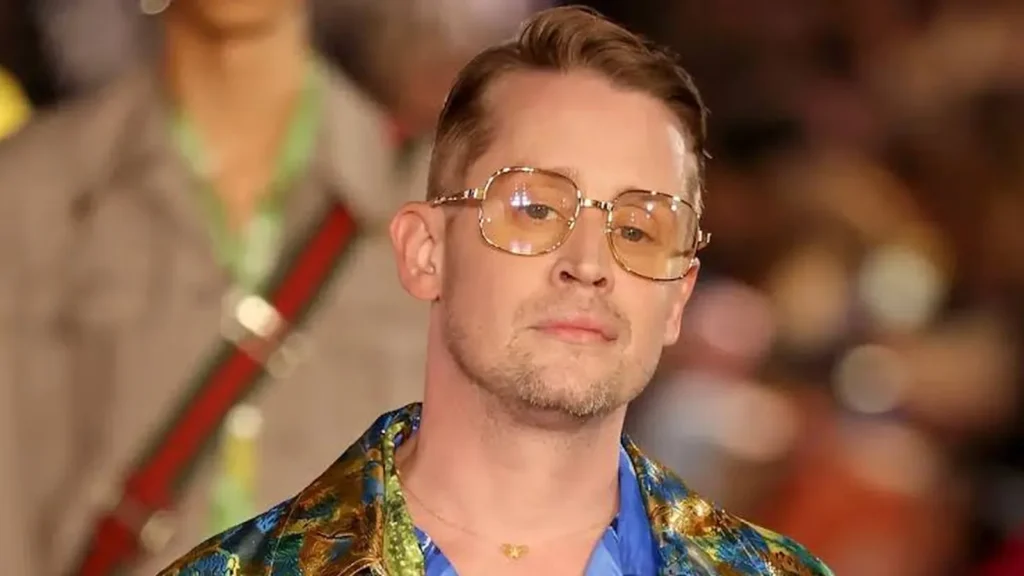 Macaulay Culkin wearing glasses at a red carpet event