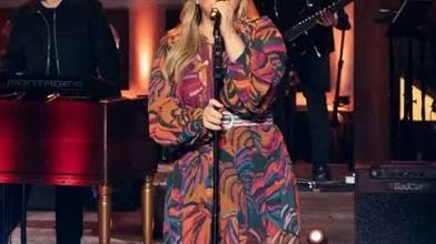 Kelly Clarkson performing live on stage in printed outfit